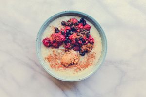 Photo of vegan oatmeal with raspberries, bluberries and peanut butter
