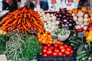 Photo of carrots, onions, tomatoes and parceley at a farmers market.