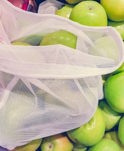 Photo of apples in produce section at store with fabric produce bag